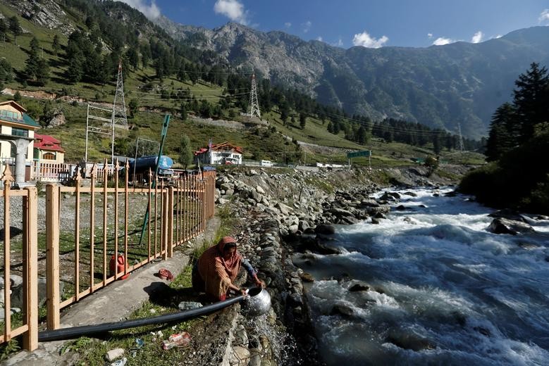 A woman fills her container using a water pipe alongside a stream at Gagangeer in Kashmir's Ganderbal district. REUTERS/Danish Ismail